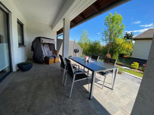 a patio with a table and chairs on a patio at Renoviertes Ferienhaus in Harbshausen mit Terrasse, Grill und Garten in Vöhl