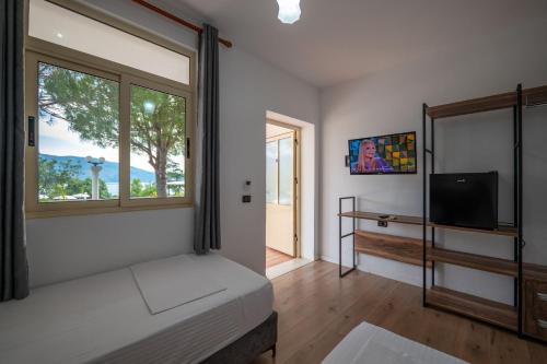a bedroom with a bed and a window at Edva Resort in Vlorë