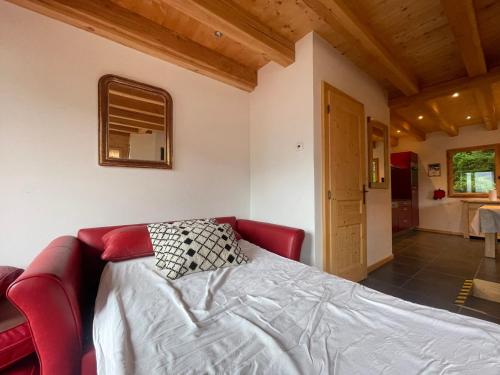 - une chambre avec un lit et un canapé rouge dans l'établissement Chalet tradition 6 pers avec cheminée, balcon et parking à Samoëns - FR-1-624-124, à Samoëns