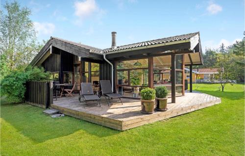 a house with a wooden deck in the grass at Holiday Home Rønnevej Fjerritslev Ix in Fjerritslev