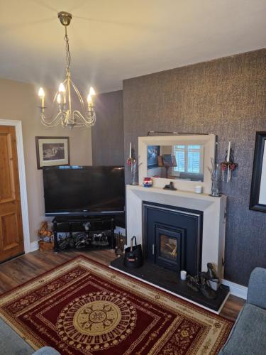 a living room with a fireplace and a television at Sutzus in Coleraine
