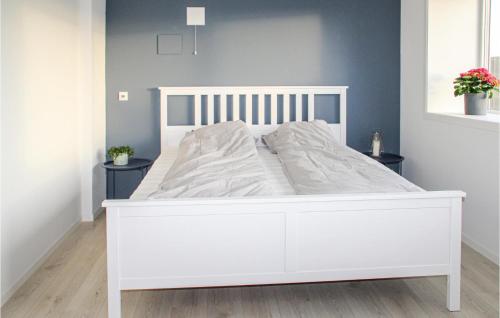 a white bed in a bedroom with two tables at Stunning Home In Farsund With Wifi in Farsund