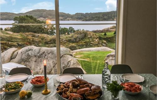 a table with a plate of food on a table with a window at Stunning Home In Farsund With Wifi in Farsund