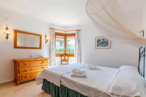 Charming Villa in Teulada with Private Pool في تيولادا: غرفة نوم بسرير وخزانة ونافذة