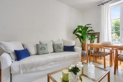 - un salon avec un canapé blanc et des oreillers bleus dans l'établissement Appart hyper centre - 270m de la plage de l Ecluse, à Dinard