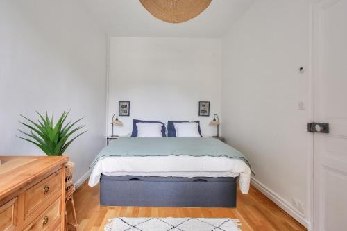 une chambre avec un lit avec des oreillers bleus et blancs dans l'établissement Appart hyper centre - 270m de la plage de l Ecluse, à Dinard