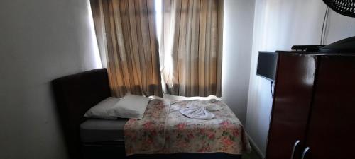 a small bedroom with a bed and a window at Hotel Dal Gobo in Ponta Grossa