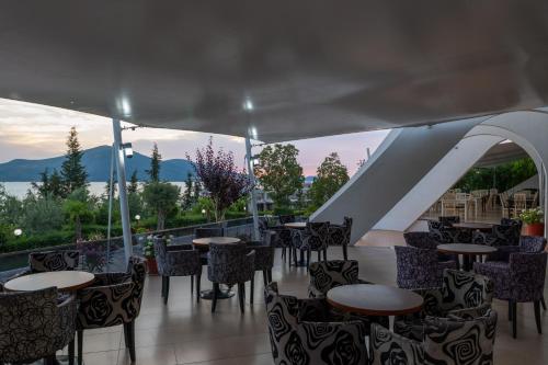 a restaurant with tables and chairs with a view at Edva Resort in Vlorë