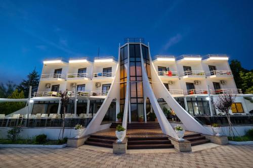 a white building with a slide in front of it at Edva Resort in Vlorë