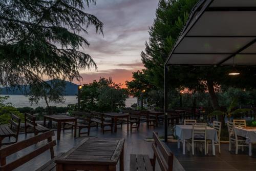 a restaurant with tables and chairs with a sunset in the background at Edva Resort in Vlorë