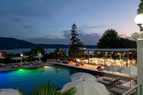 a pool with chairs and umbrellas at a resort at Edva Resort in Vlorë