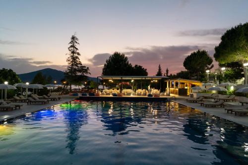 a pool at a resort at night at Edva Resort in Vlorë