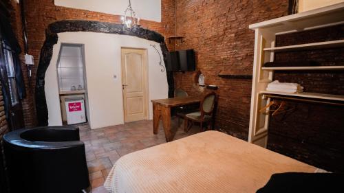 a room with a brick wall and a table and a desk at Pasaje Solar in Buenos Aires