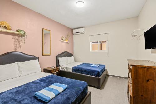 a bedroom with two beds and a flat screen tv at Curadise Living in Willemstad