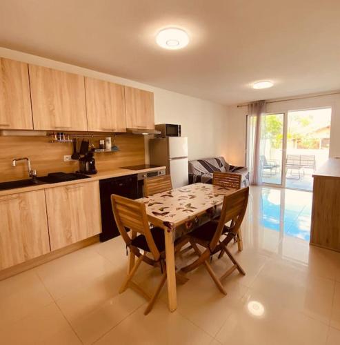 - une cuisine avec une table et des chaises en bois dans la chambre dans l'établissement Apt climatise avec terrasse et stationnement 100 metres de la plage V0825, à Vias