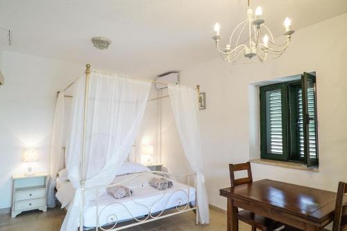 a bedroom with a bed and a table and a chandelier at Ferienhaus in Zagvozd mit Privatem Pool in Zagvozd
