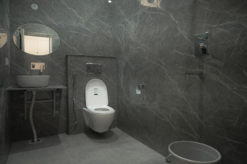 a bathroom with a toilet and a sink and a mirror at Mount Valley Mama Cottage in Rishīkesh