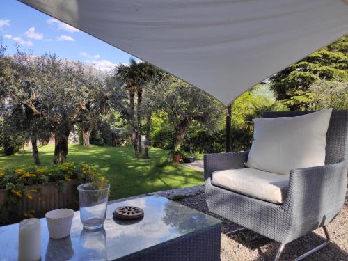 a patio with a chair and a table at Villa Riva Lago - Apartment with garden and parking in Tavernola Bergamasca