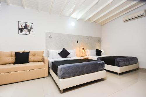 two beds and a couch in a room at Naiot Hotel Boutique in Medellín