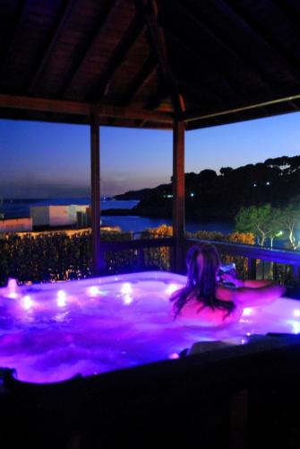a girl laying in a hot tub with purple lights at La Muntanya in Llafranc