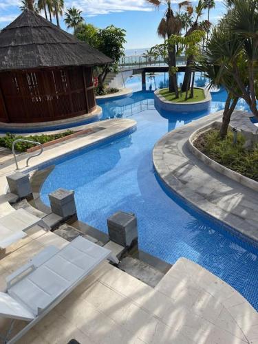 a large swimming pool with a building in the middle at HAPPY Luxury Apartment - Beachside in Mar Azul, Estepona in Estepona