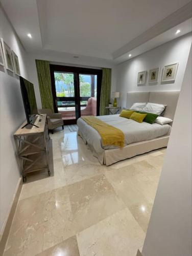 a bedroom with a bed and a television in it at HAPPY Luxury Apartment - Beachside in Mar Azul, Estepona in Estepona