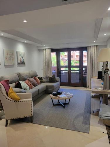 a living room with a couch and a table at HAPPY Luxury Apartment - Beachside in Mar Azul, Estepona in Estepona
