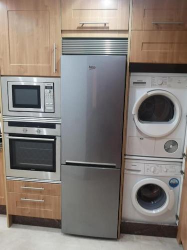 a kitchen with a refrigerator and a washer and dryer at HAPPY Luxury Apartment - Beachside in Mar Azul, Estepona in Estepona