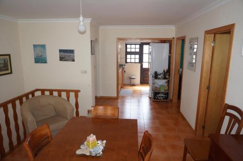 a dining room with a table and chairs and a hallway at Holiday House Tocha in Palheiros da Tocha