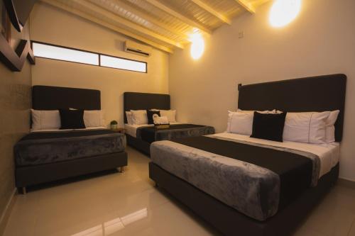 a bedroom with two beds and a couch at Naiot Hotel Boutique in Medellín