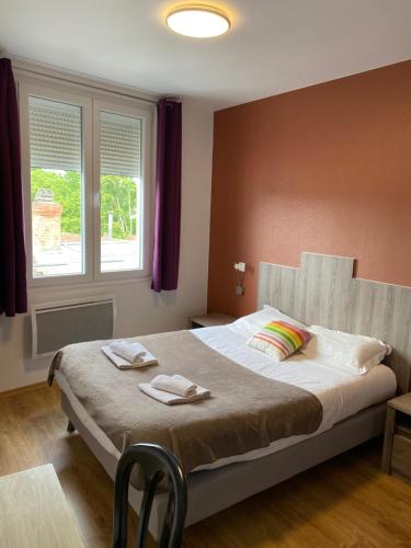 a bedroom with a bed with two towels on it at Hôtel Le Saint Amand in Saint-Amand-Montrond