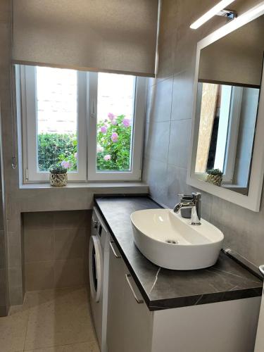 a bathroom with a sink and two windows at Apartment Dora 1 , on the beach in Tivat