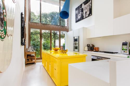 a kitchen with yellow cabinets and a large window at Magic Forte in Forte dei Marmi