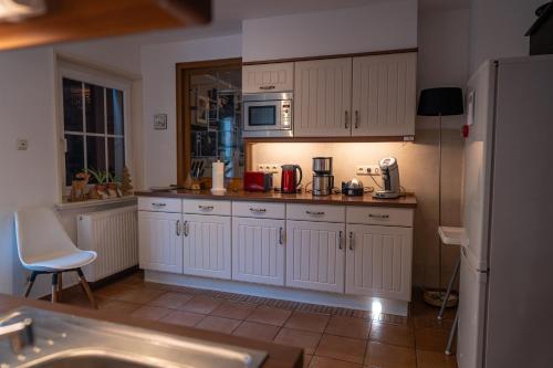 a kitchen with white cabinets and a counter top at Jachthuus in Brilon