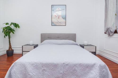 a bedroom with a white bed with two night stands at Opera Venice Apartment in Mestre