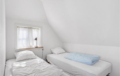 two beds in a room with a window at One-Bedroom Holiday Home In Allinge in Allinge