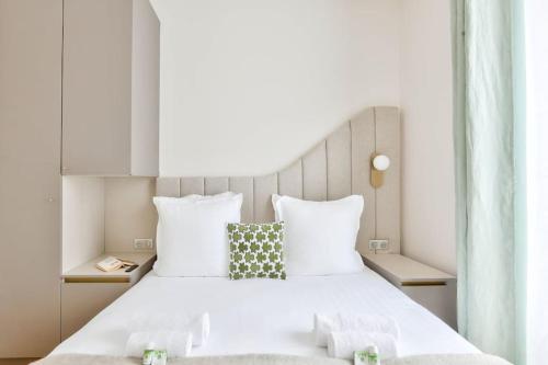 une chambre avec un grand lit blanc avec deux oreillers dans l'établissement Luxurious Family Flat - Le Marais - With AC, à Paris