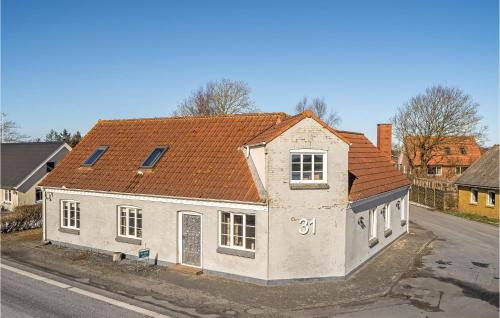 a white house with an orange roof on a street at 4 Bedroom Pet Friendly Home In Spøttrup in Spottrup