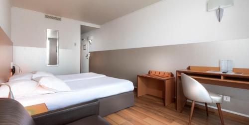 a hotel room with a bed and a desk at Hôtel Du Lion in Paris