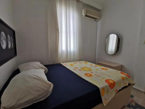 a small bedroom with a bed with a sheet on it at Kuşadası Davutlar'da Huzur Rahat ve Konfor Bir Arada in Aydın