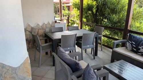 an outdoor patio with a table and chairs at Kuşadası Davutlar'da Huzur Rahat ve Konfor Bir Arada in Aydın