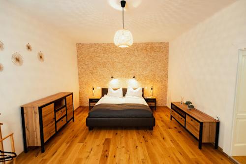 a bedroom with a bed and wooden floors and a wall at Casa Leonhardt in Sighişoara