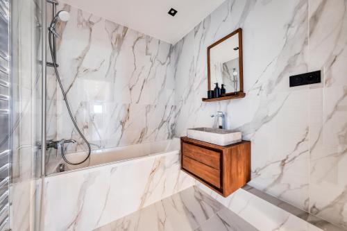 une salle de bain avec une baignoire, un lavabo et un miroir dans l'établissement Appartement Luxe 3 Chambres Lits Doubles 6 Personnes - Proche Paris 16, Parc des Princes, Roland-Garros, à Boulogne-Billancourt