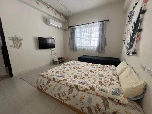 a bedroom with a bed and a television in it at Come Home Travel in Tainan