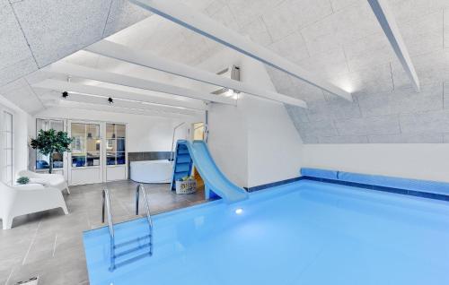 a swimming pool in a room with a slide at Lovely Home In Ulfborg With Sauna in Ulfborg