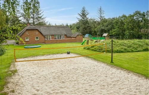 a backyard with a playground with a house at Lovely Home In Ulfborg With Sauna in Ulfborg