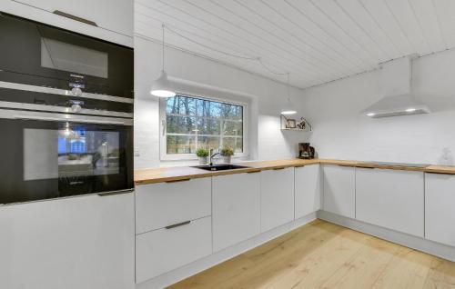 a kitchen with white cabinets and a window at Lovely Home In Ulfborg With Sauna in Ulfborg