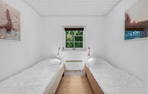 two beds in a room with white walls and a window at Lovely Home In Ulfborg With Sauna in Ulfborg