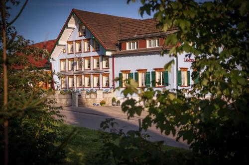 a large white building with green shutters at Hotel Landgasthaus Neues Bild, Eggerstanden in Appenzell