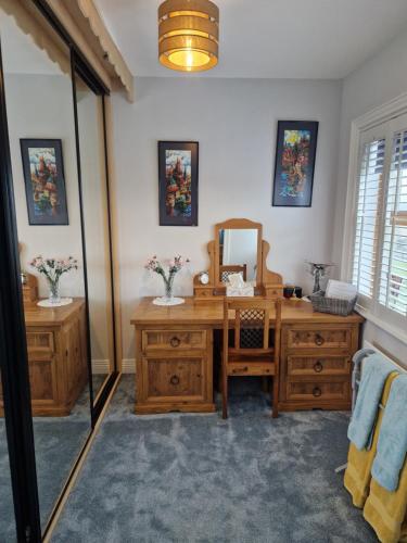 a bathroom with a wooden desk and a mirror at Sutzus in Coleraine